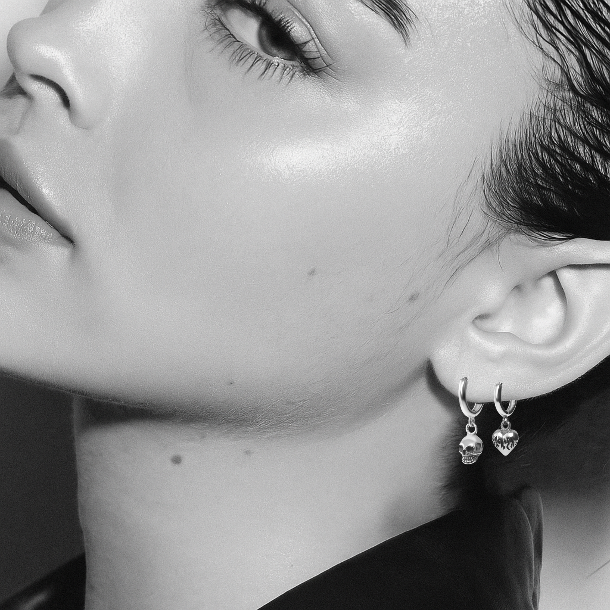 Close-up of a person wearing skull-shaped earrings.